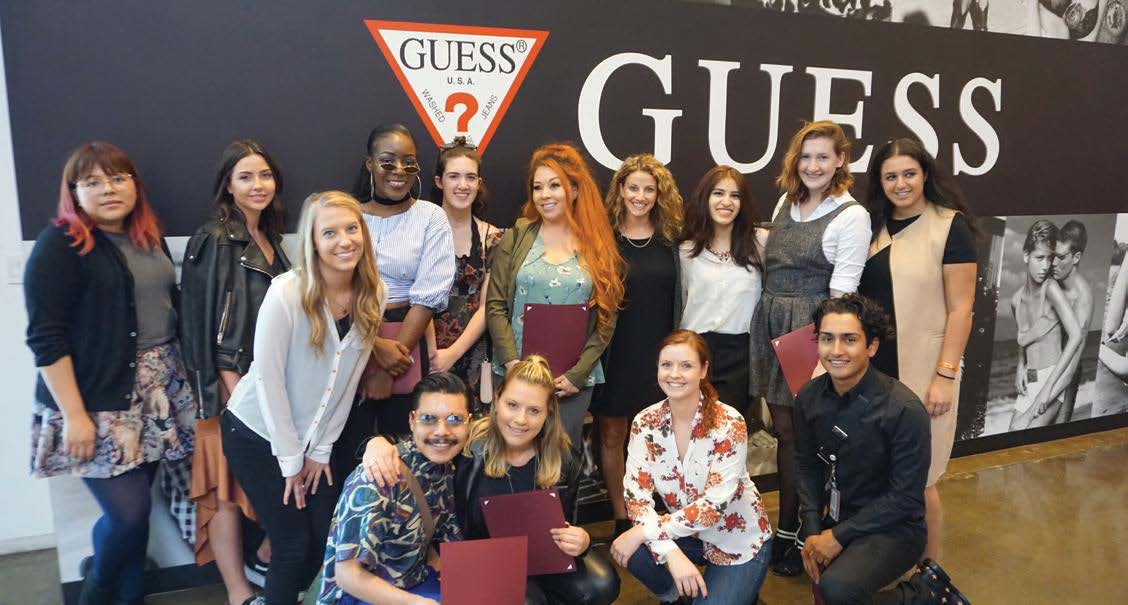 group in front of guess poster