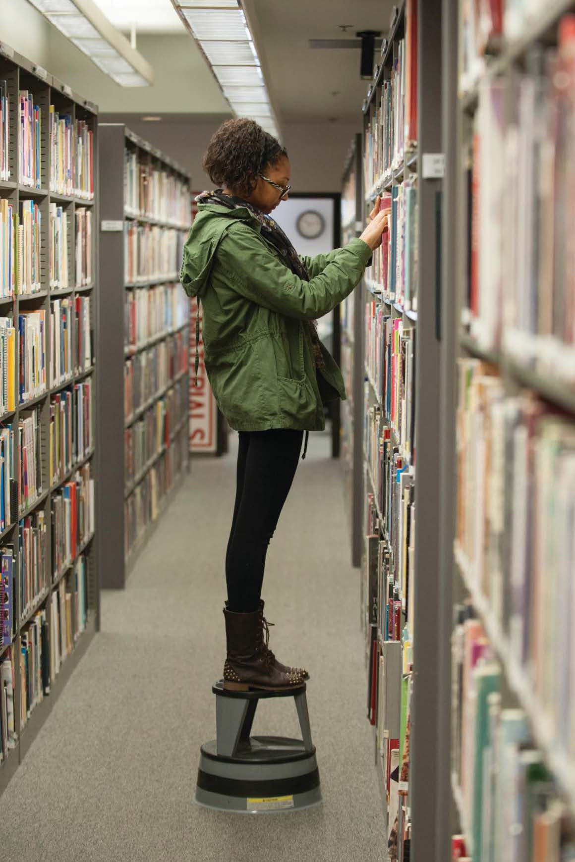 girl in library on stool