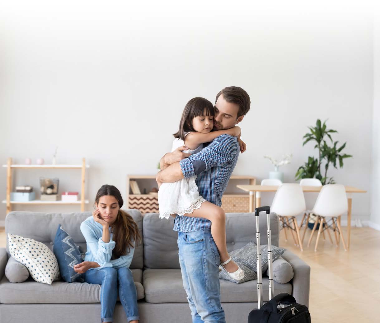 mand holding child and woman sitting in living room