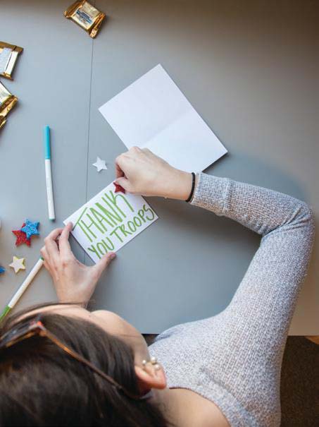 girl writing thank you letter to troops